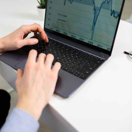 anonymous businessman working on financial project using laptop in office