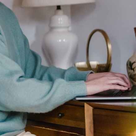 smiling woman typing on laptop at home
