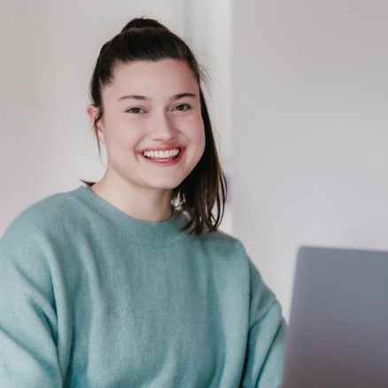 smiling woman working on laptop at home