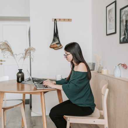 female remote worker typing on laptop at home