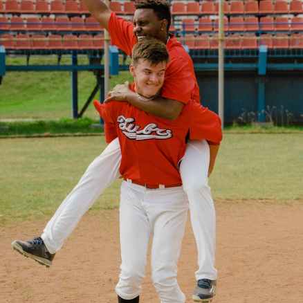 man in red jersey carrying his teammate on his back